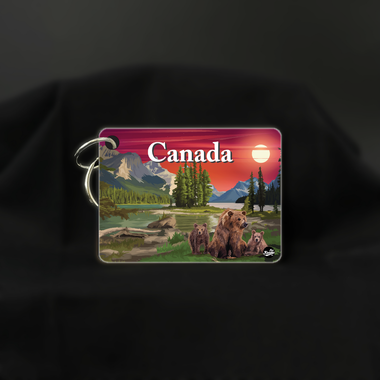 Canadian Rockies bear key chain by New Klondike Arts featuring a sunrise scene with a bear silhouette.