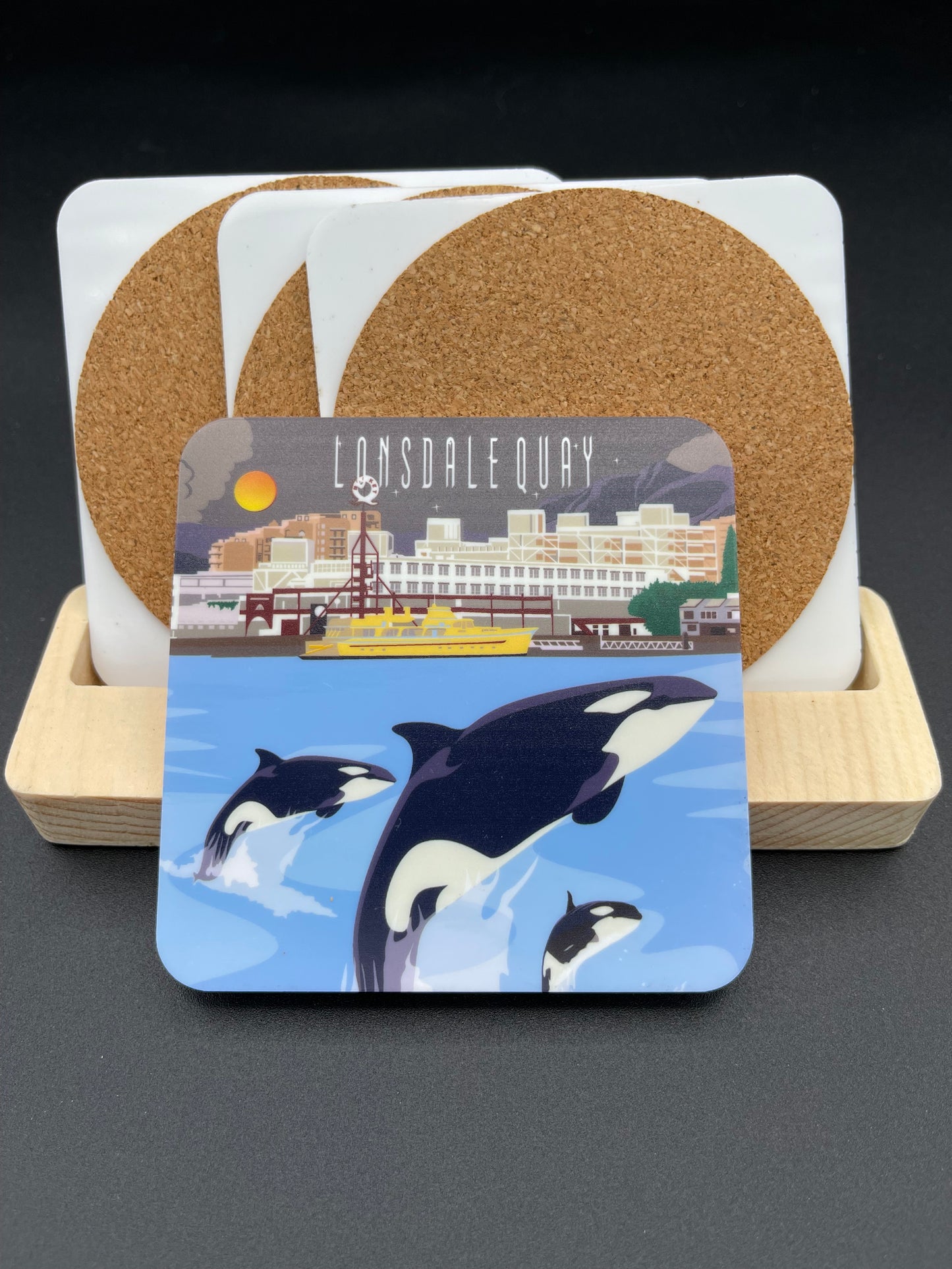 Art coaster featuring Lonsdale Quay and orca whale design by New Klondike Arts and Media, showcasing vibrant daytime scenery.